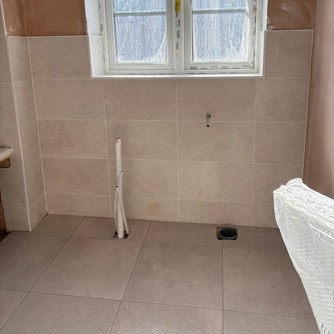 Bathroom wall and floor tiling around a bath by LN Ceramics