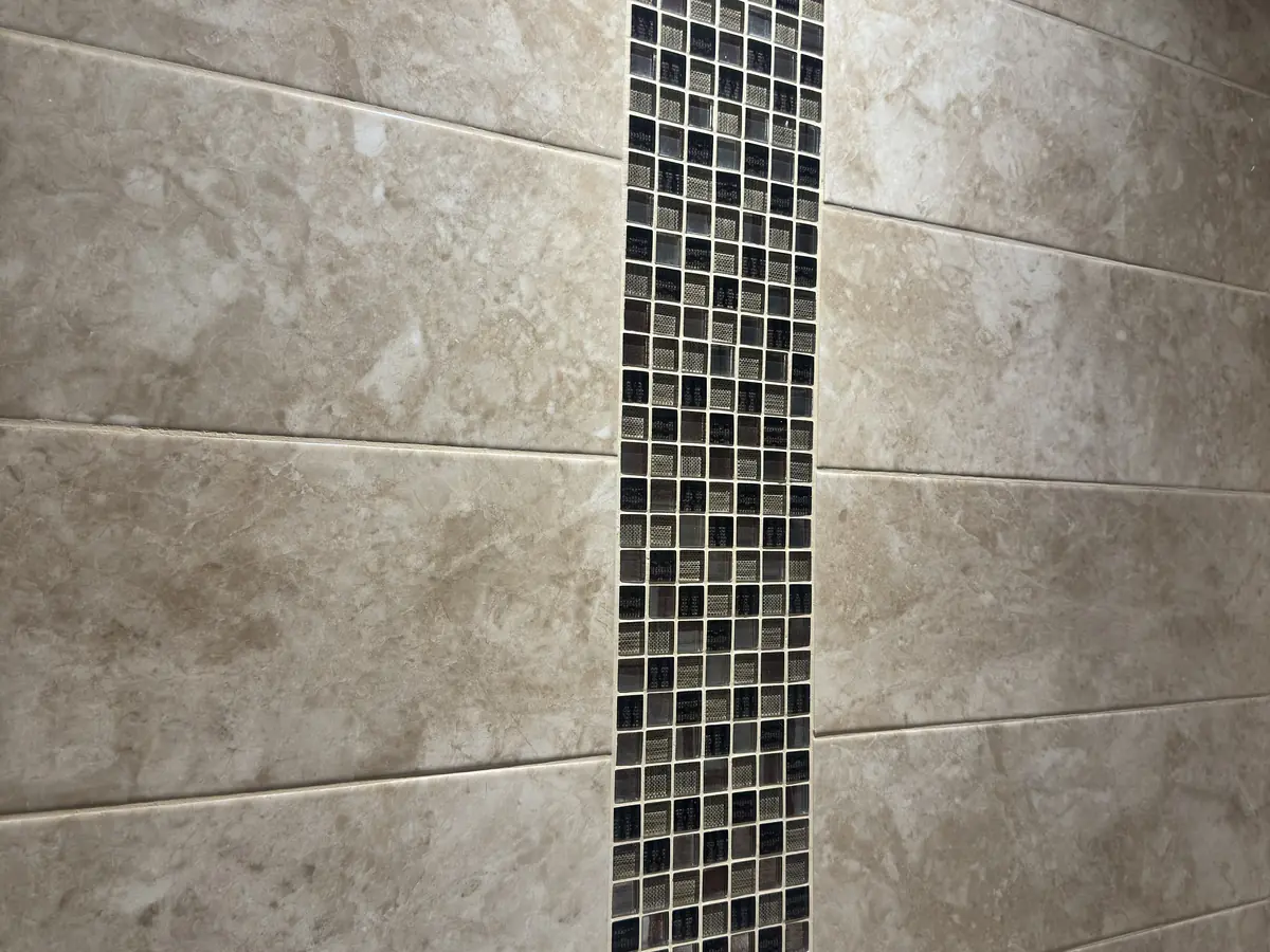 Mosaic feature strip on a tiled bathroom wall by LN Ceramics